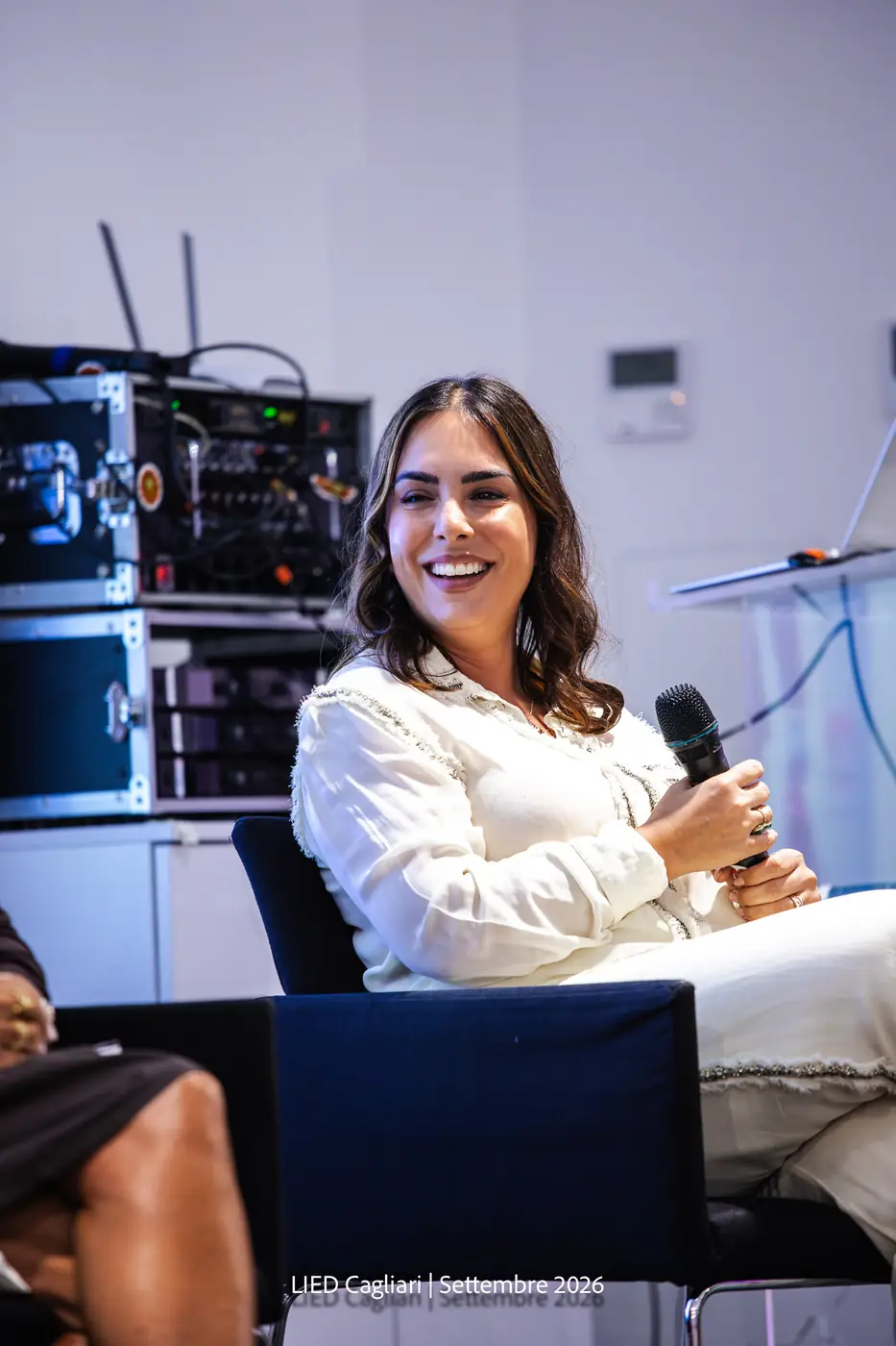 Cagliari — L'Impresa è Donna 2026 Una partecipante sorride mentre interviene al microfono dalla platea