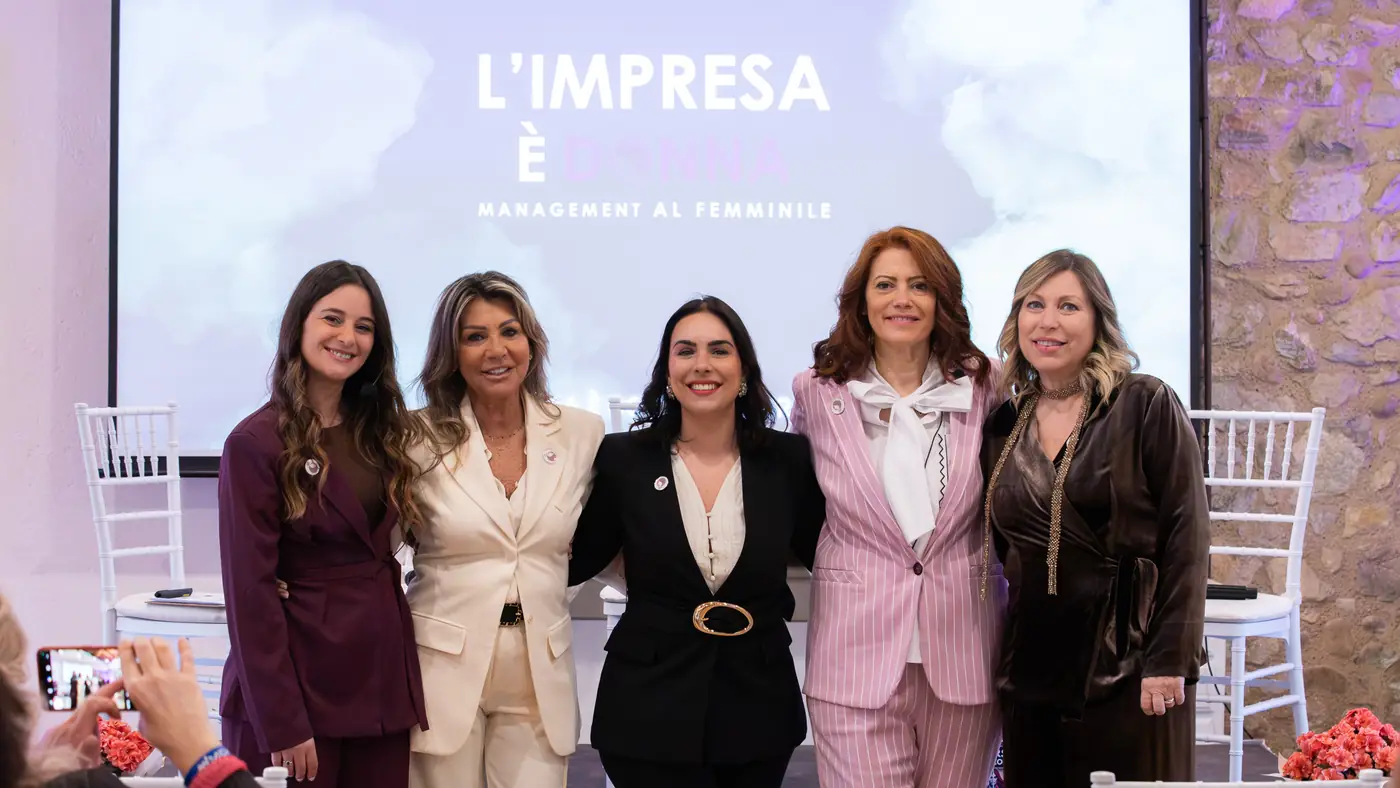 Desenzano del Garda — L'Impresa è Donna 2026 Le cinque relatrici della tappa di Desenzano in posa davanti allo schermo con il logo L'Impresa è Donna