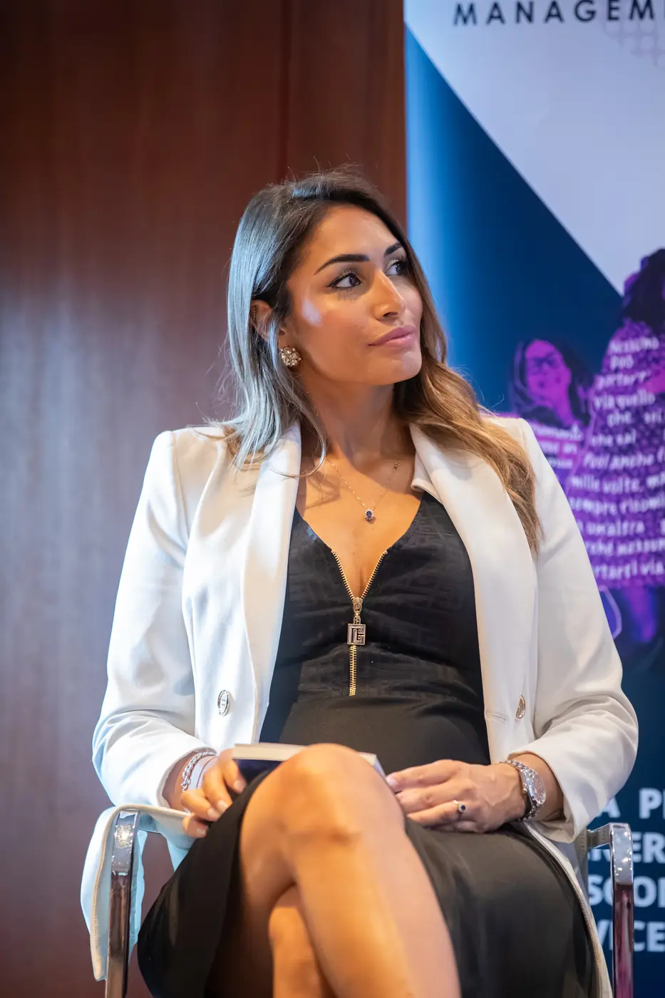Genova — L'Impresa è Donna 2026 Una relatrice in blazer bianco e abito nero ascolta gli altri interventi