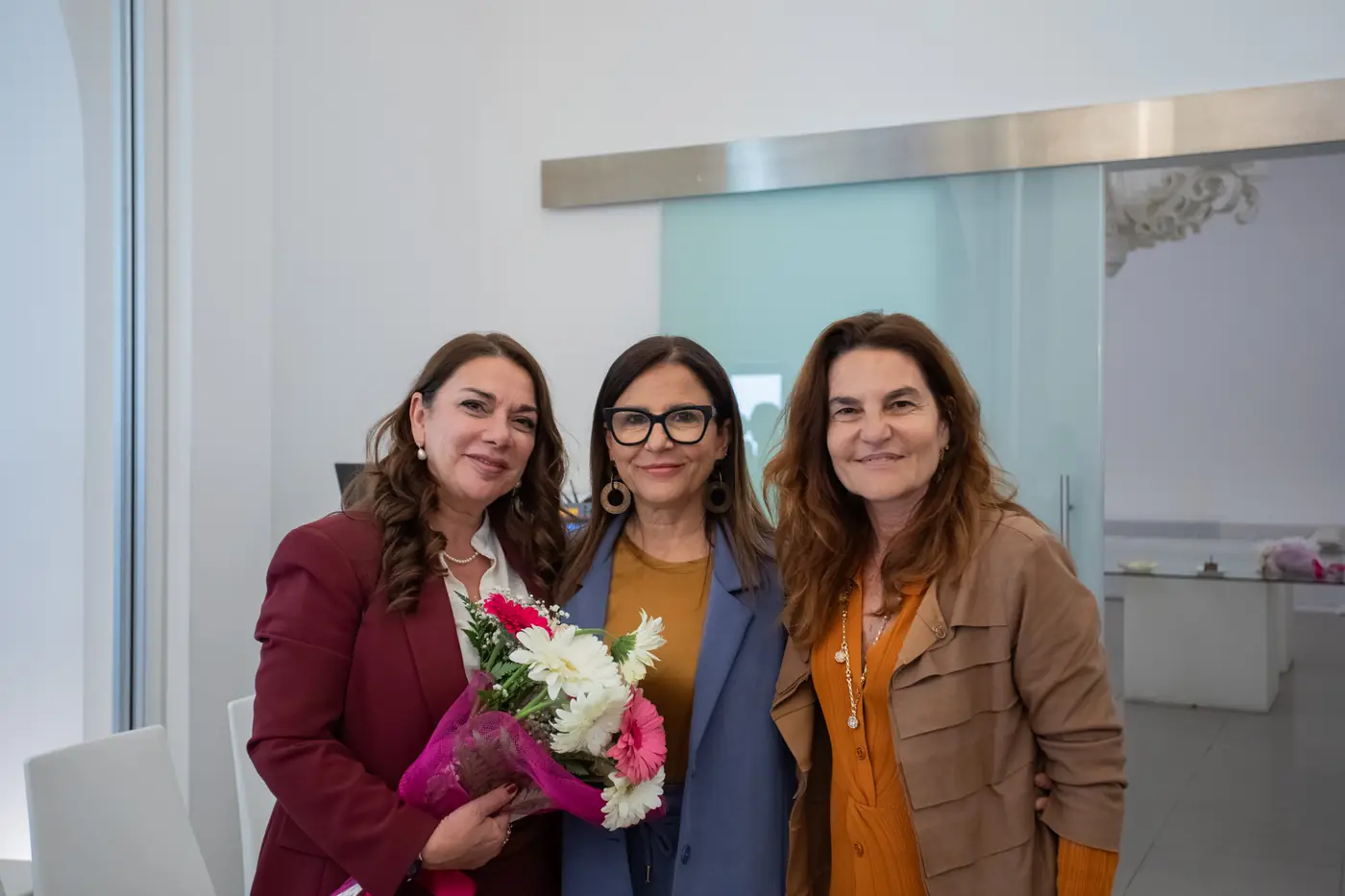 Palermo — L'Impresa è Donna 2026 Tre partecipanti in posa con un mazzo di fiori dopo la premiazione